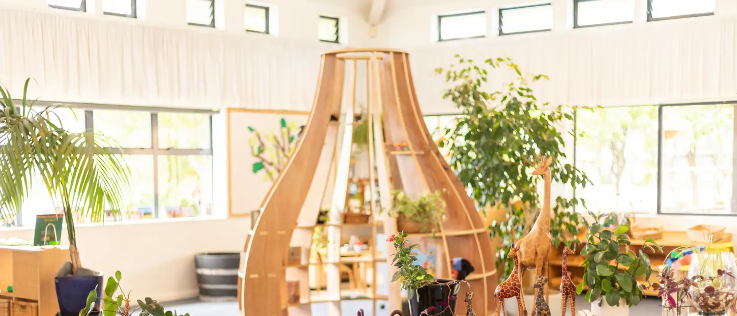 The main hall at Northcross, with a tall wooden nest structure, skylights and plants around it.