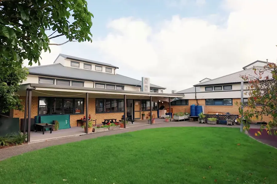 The lawn at Northcross, with the brick centre building and its covered deck behind it.
