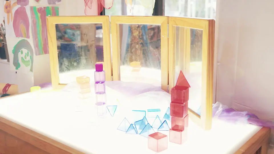 Mirrors and coloured see-through shapes on a light table.